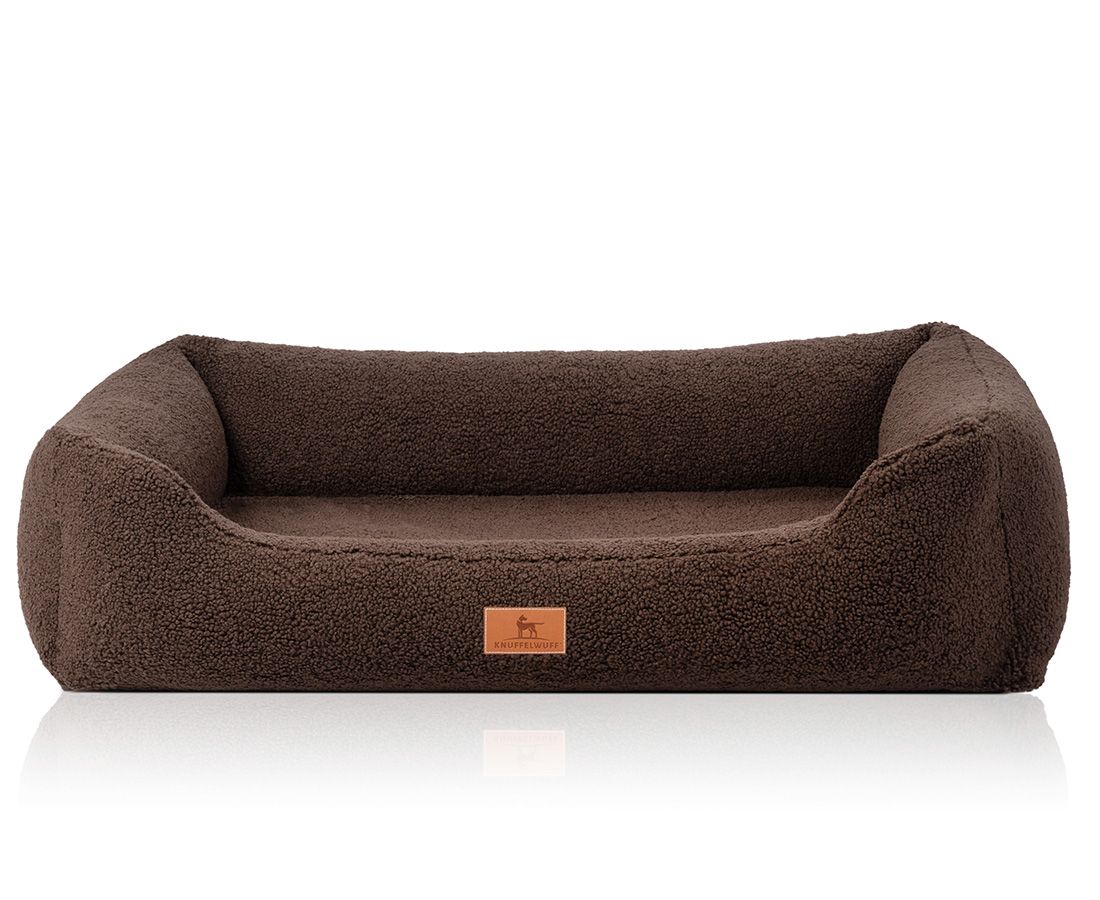 Braunes orthopädisches Hundebett. Rechteckige Form mit erhöhten Seiten. Aufgenähtes Markenlogo. Weiches, strukturiertes Material.