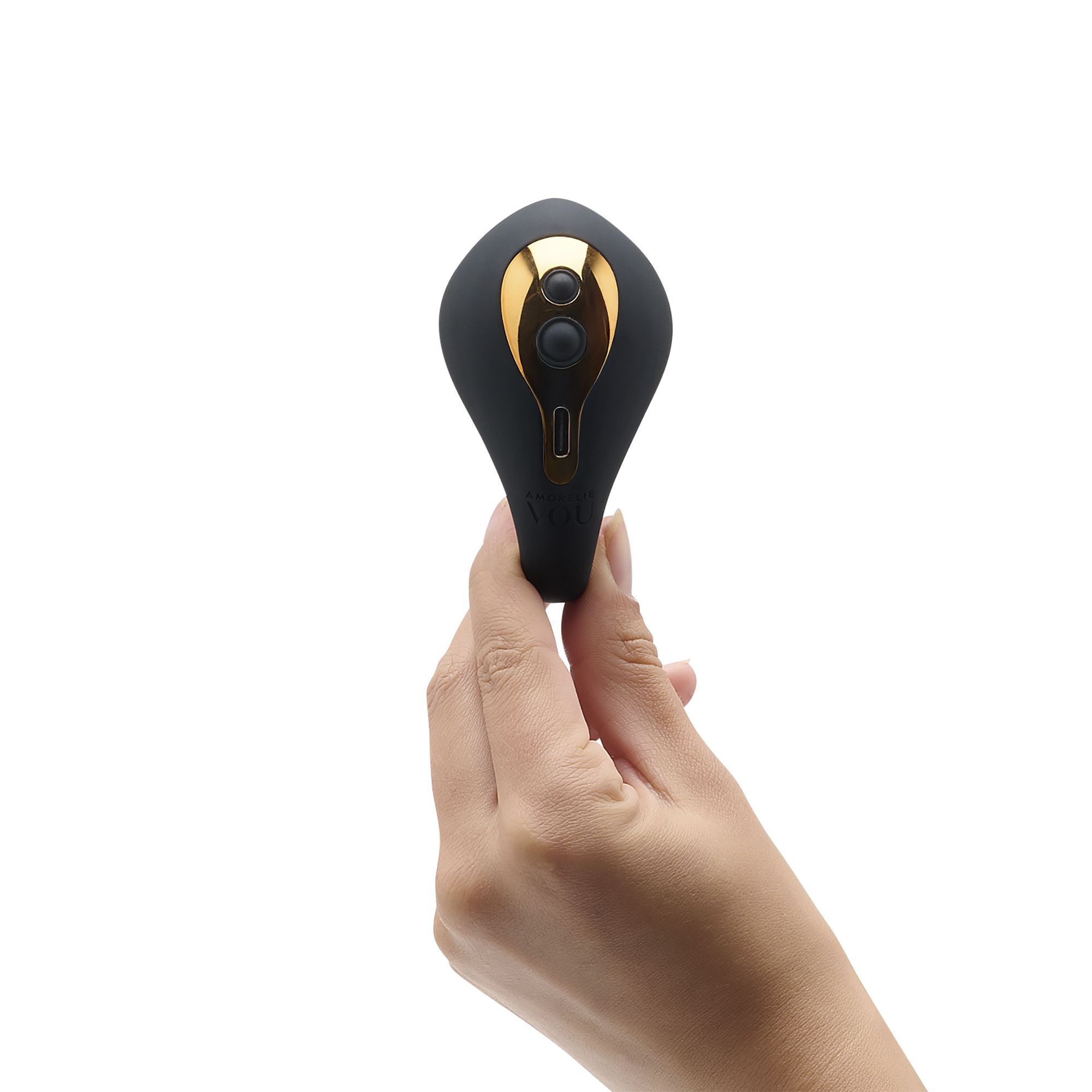 Schwarzer C-förmiger Vibrator, gehalten von einer Hand. Goldfarbene Bedienelemente und Ladeanschluss.