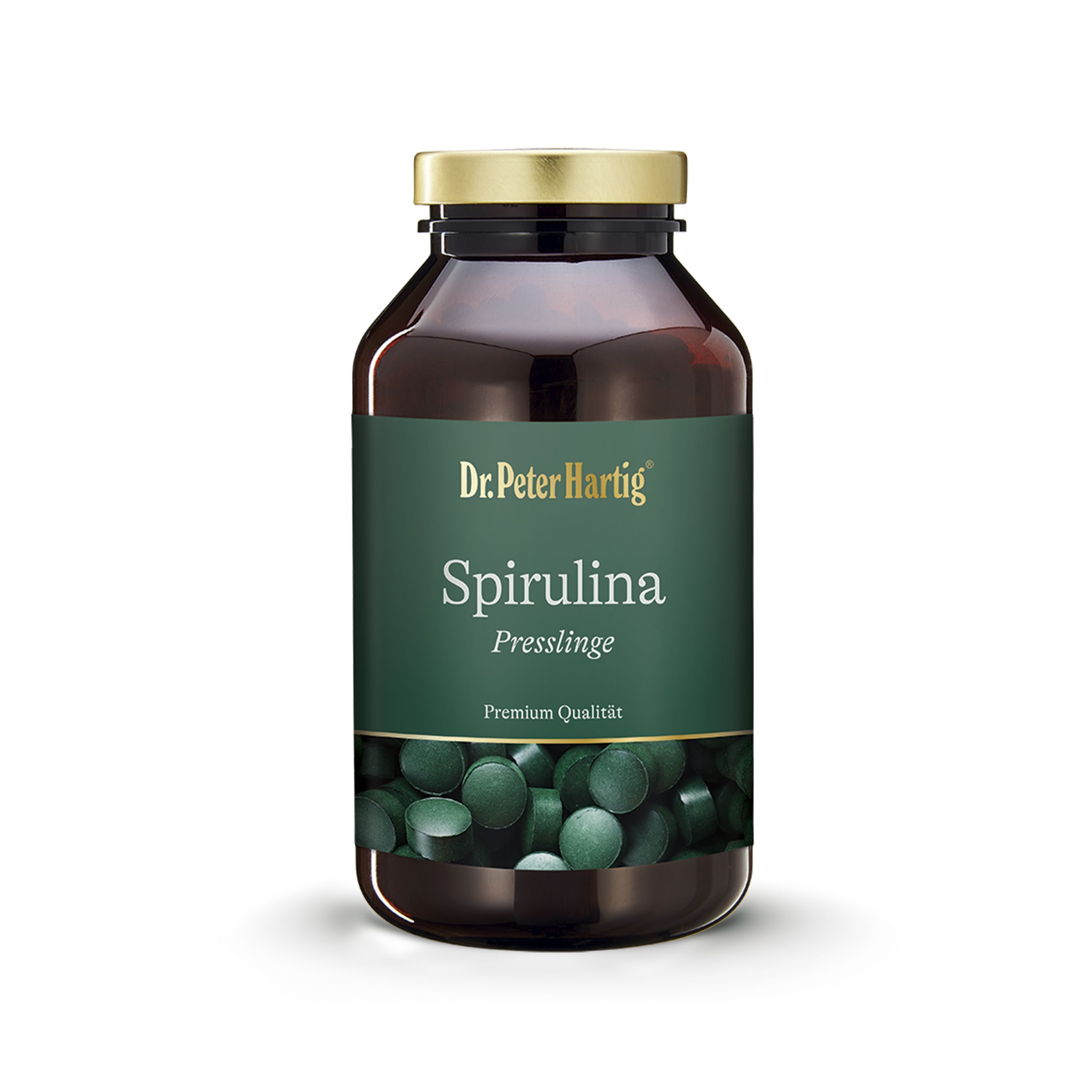 Braune Glasflasche mit goldfarbenem Deckel. Etikett mit "Dr. Peter Hartig Spirulina Presslinge". Grüne Tabletten sichtbar.