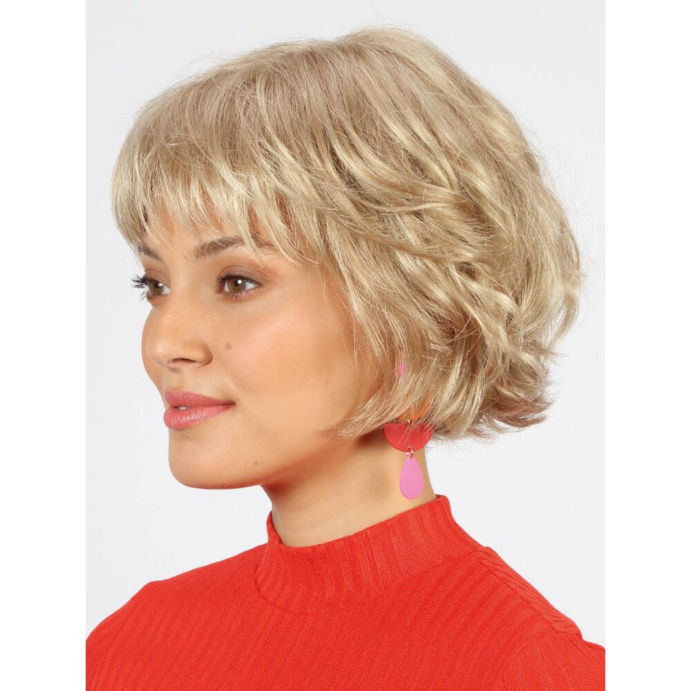 Weißblonde Perücke mit kurzem, gewelltem Schnitt. Frau trägt rotes Oberteil und rosa Ohrringe. Seitenansicht.