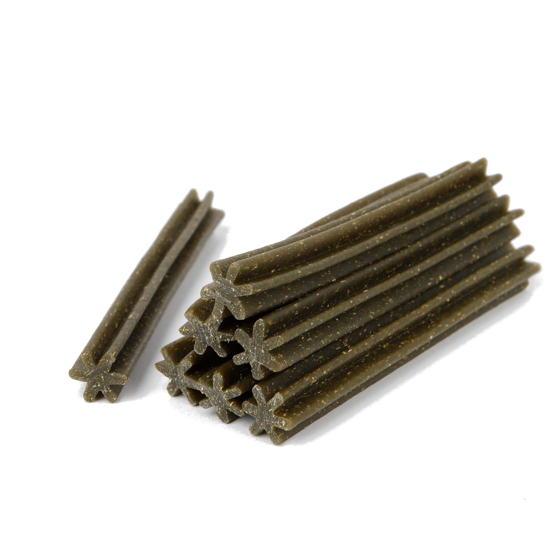 Mehrere grüne, sternförmige Dentalsticks. Einige liegen gestapelt, andere daneben.