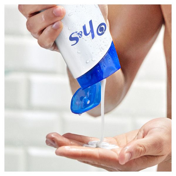 Weiß-blaue Shampoo-Flasche, Produkt wird in die Hand gegossen. S&H-Logo sichtbar.