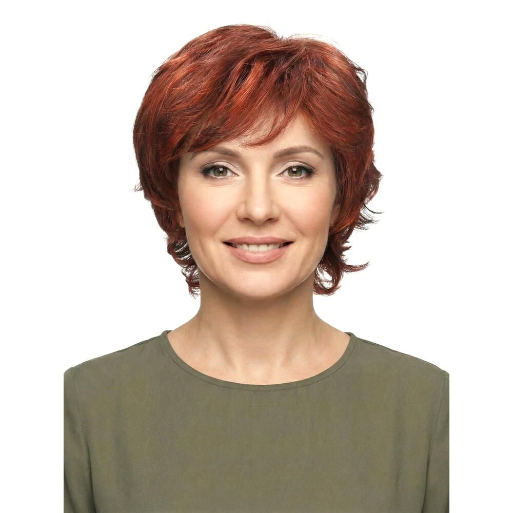 Frau mit roter Perücke. Kurzer, gewellter Haarschnitt. Frontalansicht, lächelnd.
