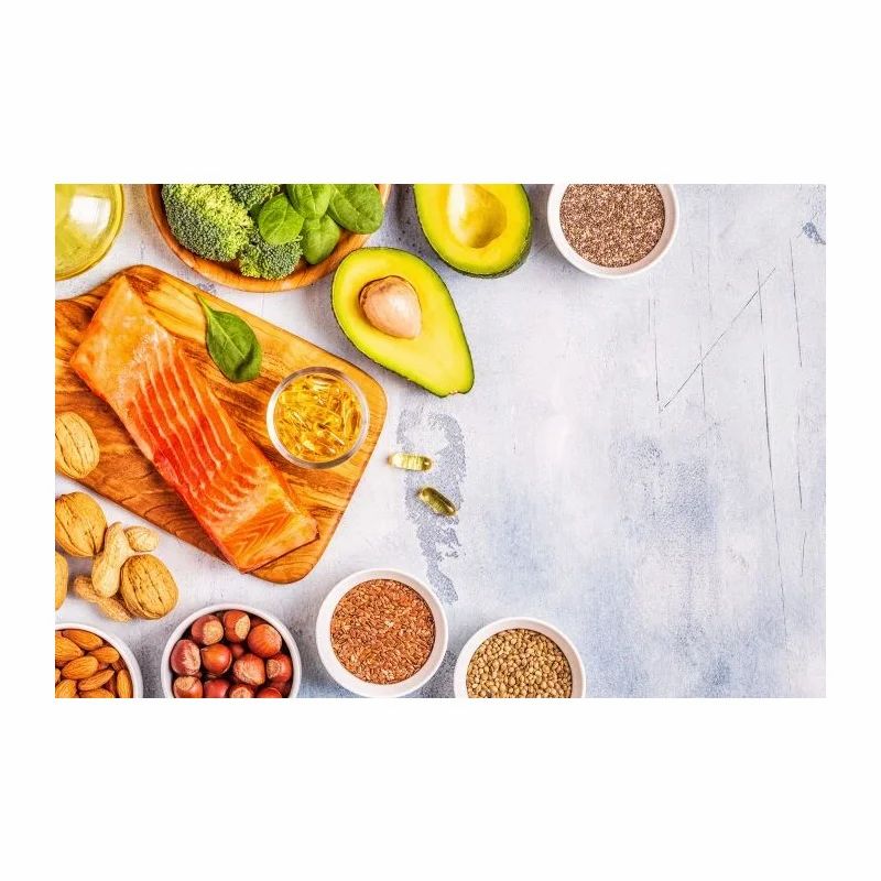 Draufsicht auf eine Auswahl an Lebensmitteln: Lachs, Avocado, Nüsse, Samen und Gemüse.