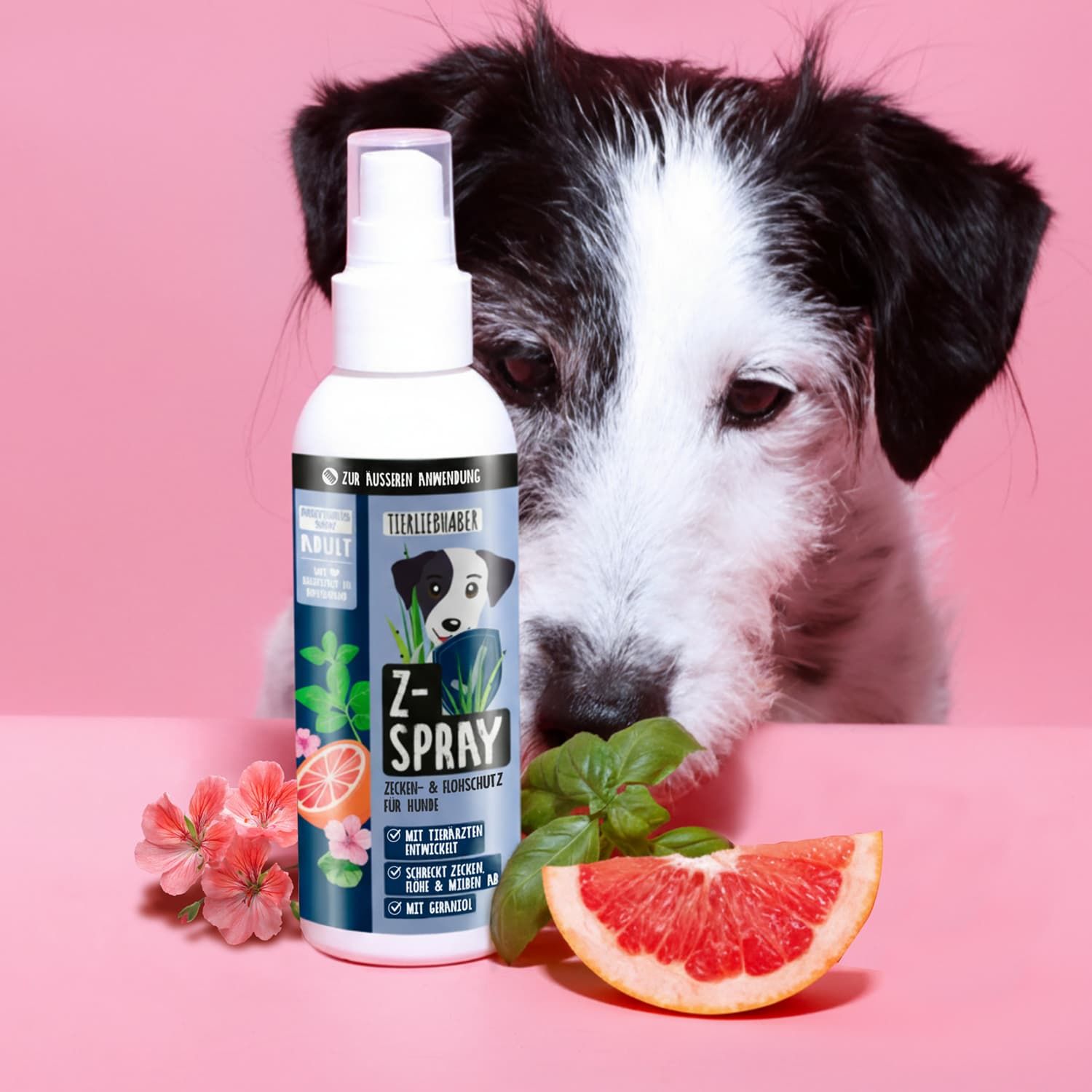 Weiße Sprühflasche mit blauem Etikett, Z-Spray-Logo, Hund, Grapefruit, Blüten und Blättern. Hintergrund: pink.