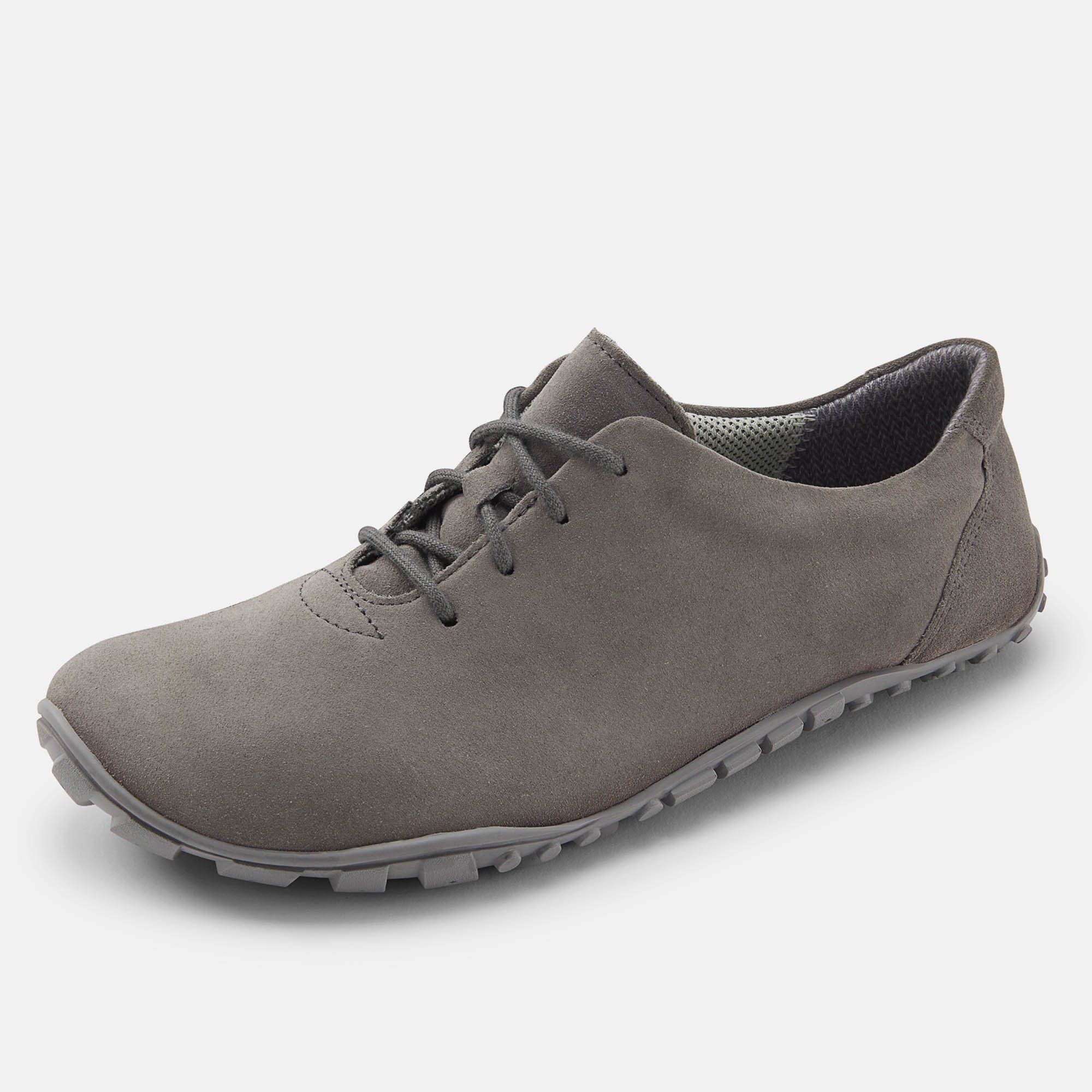 Grauer Schnürschuh. Breiter Schnitt. Sohle mit Profil. Schuh von der Seite. Graues Obermaterial.