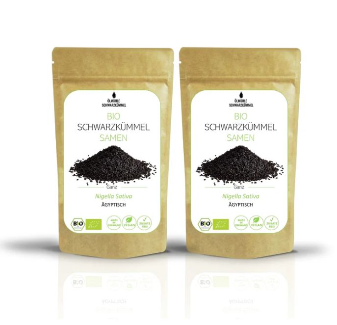 Zwei Beutel mit Bio-Schwarzkümmel Samen. Aufschrift: Bio Schwarzkümmel Samen, Nigella Sativa, Ägyptisch. Siegel: Bio-Siegel.