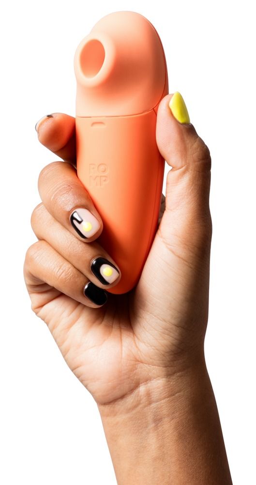 Hand hält orangefarbenes Gerät. Oberteil hellorange. ROMP-Logo. Gelbe und schwarze Nagellackakzente.