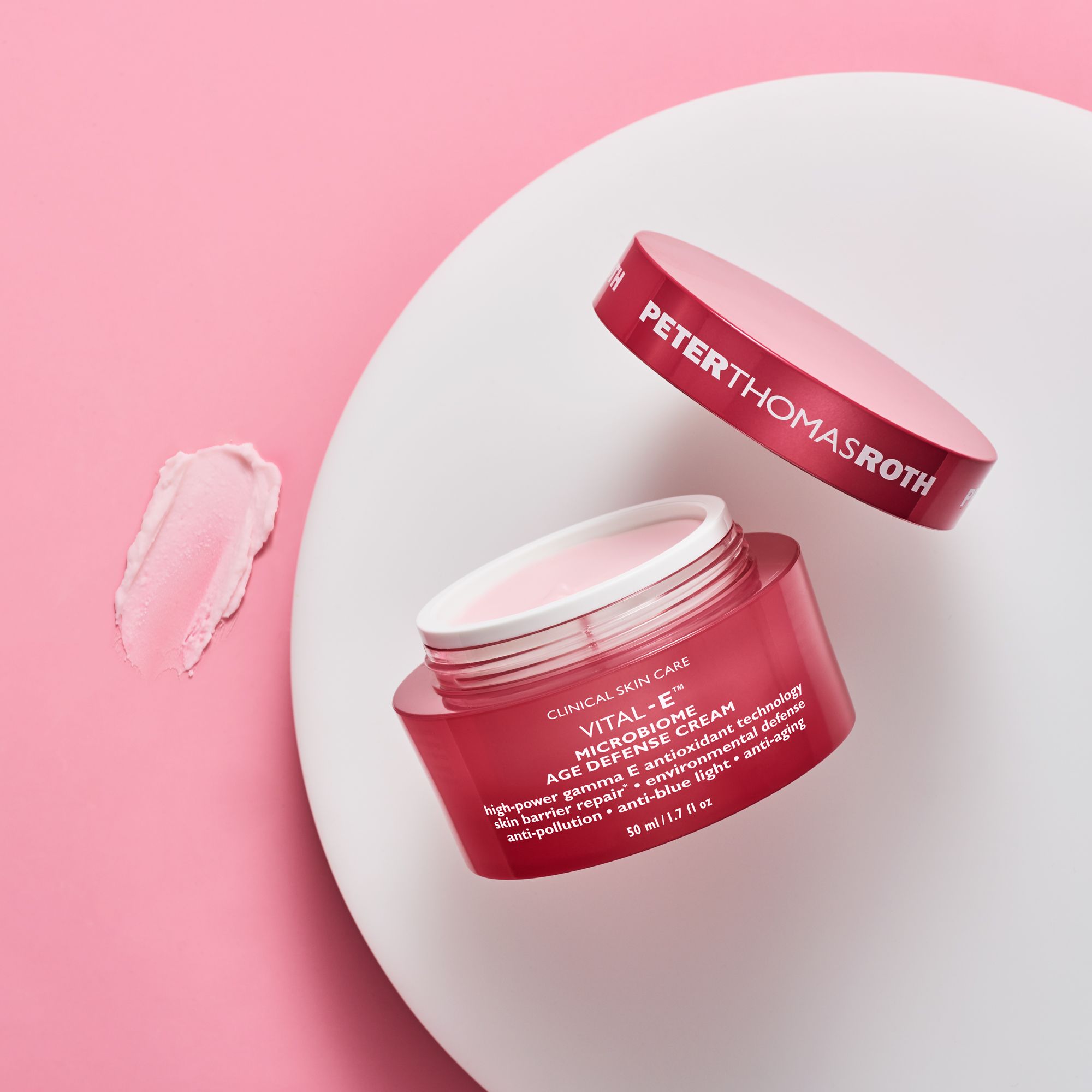 Geöffnete rosa Creme-Dose mit Deckel daneben. Aufschrift: Peter Thomas Roth, Vital-E Microbiome Age Defense Cream.