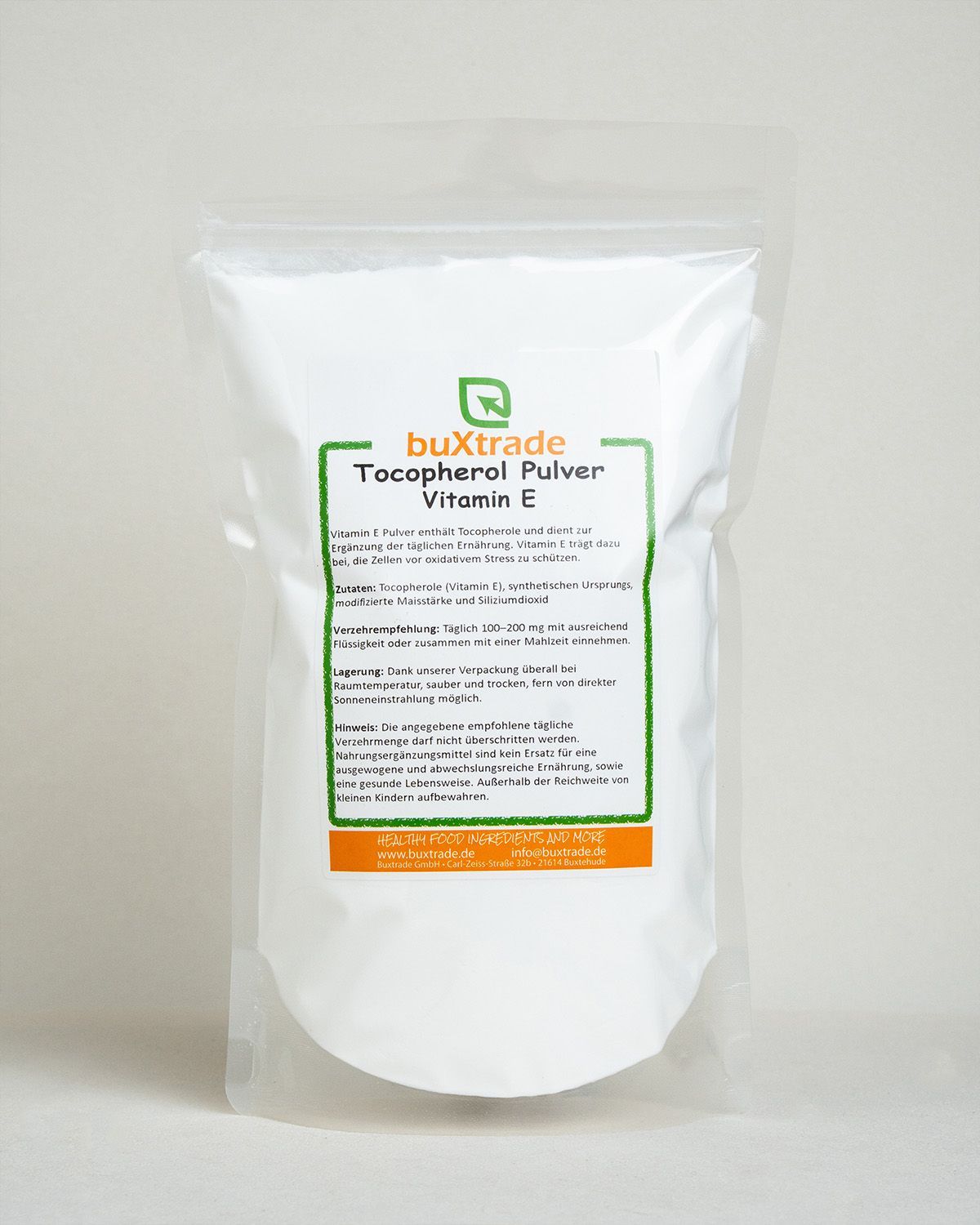 Ein weißer Beutel mit Tocopherol Pulver Vitamin E von buxtrade, auf einem Betonpodest.