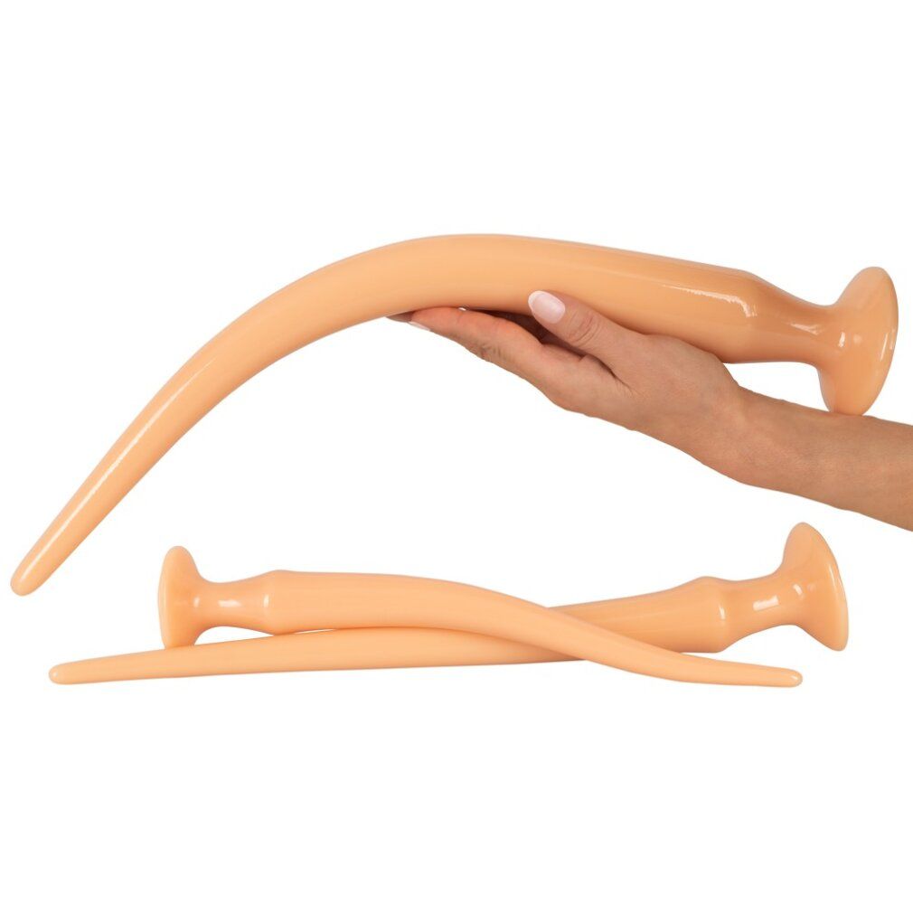 Hand hält ein gebogenes, beige Anal-Plug-Spielzeug. Zwei weitere liegen daneben.