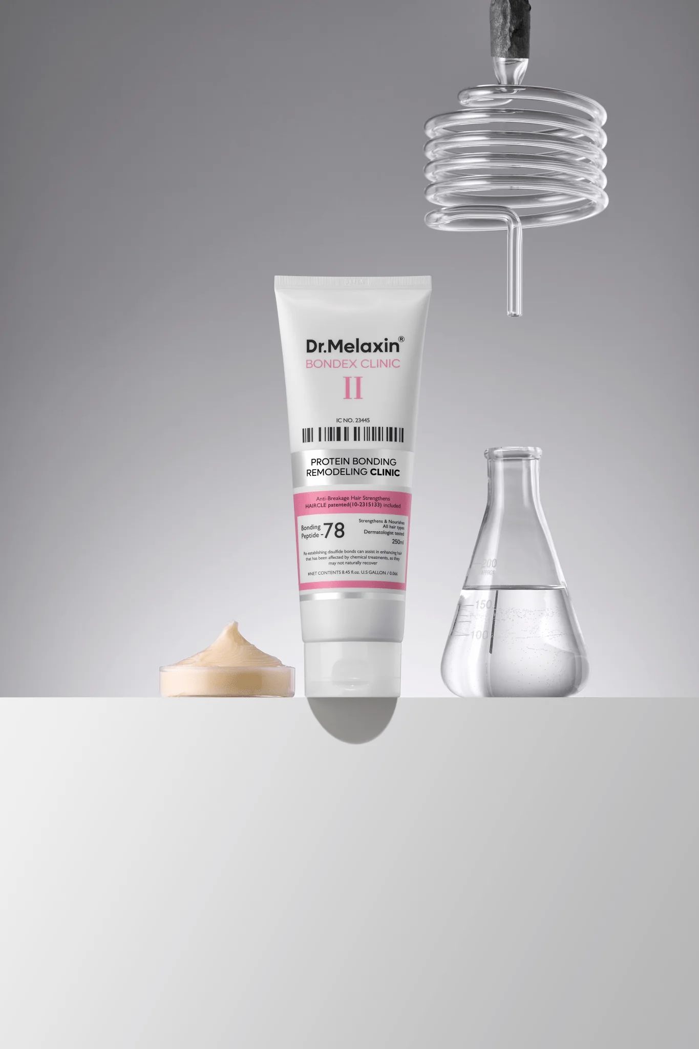 Weiße Tube mit rosa Etikett. Aufschrift: Dr.Melaxin Bondex Clinic II. Text: Protein Bonding Remodeling Clinic. Neben Reagenzgläsern und Creme.