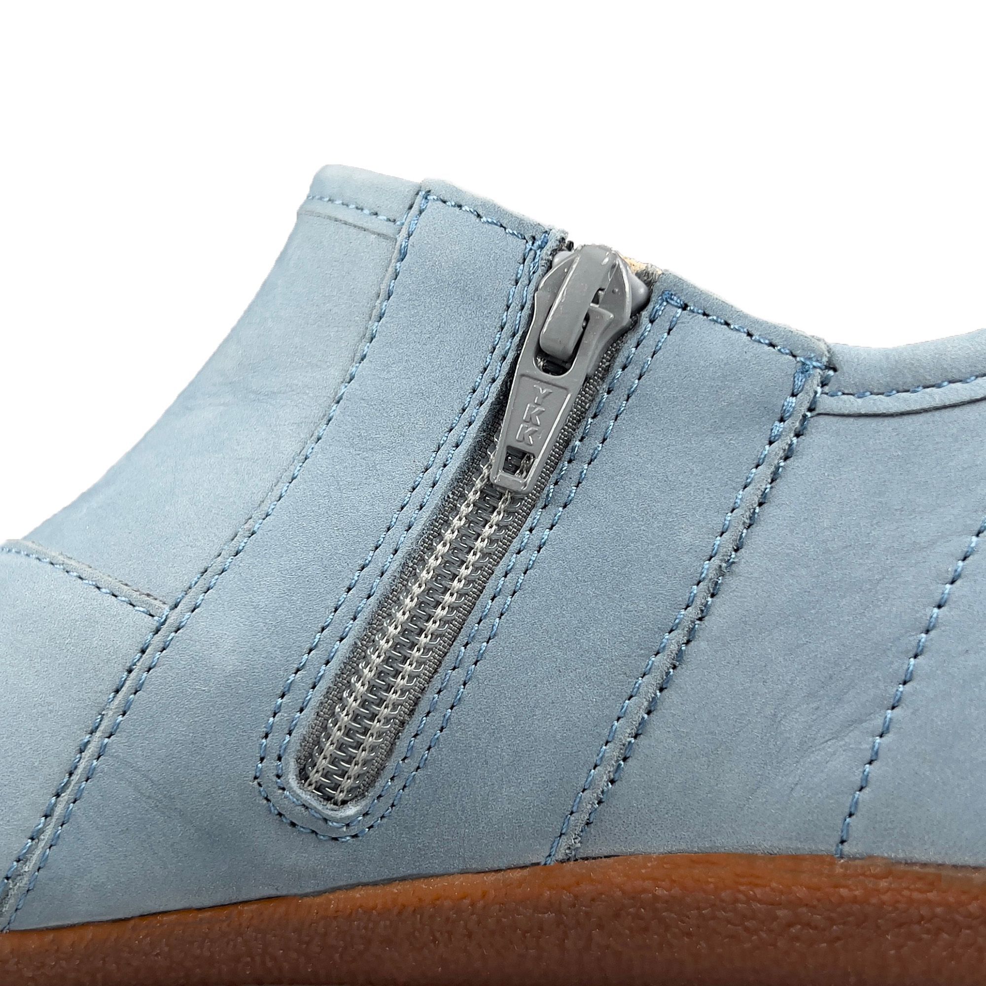 Nahaufnahme eines Reißverschlusses an einem hellblauen Slipper. Metallreißverschluss, Detailansicht.