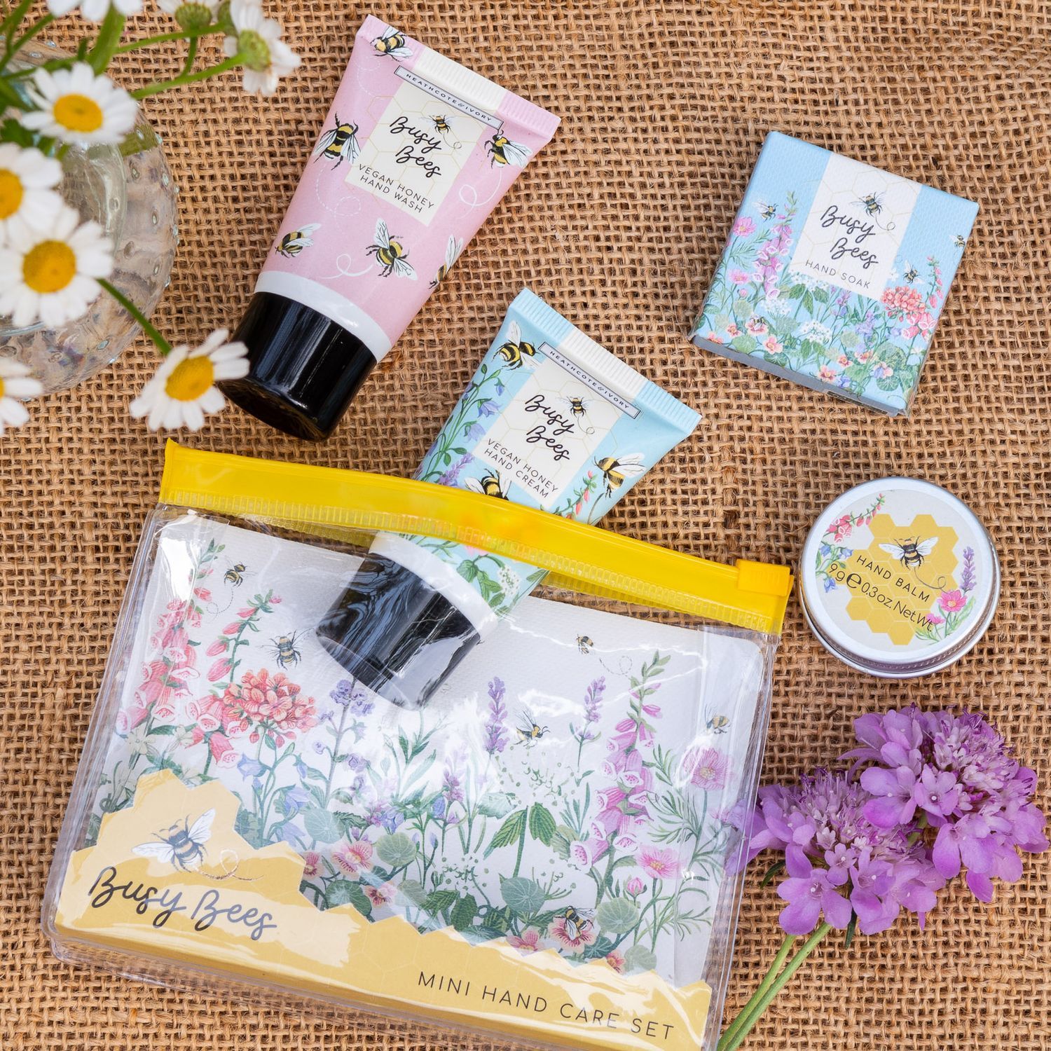Mini Handpflege-Set mit Handcreme, Handwaschmittel, Handseife und Handbalsam auf rustikalem Hintergrund.