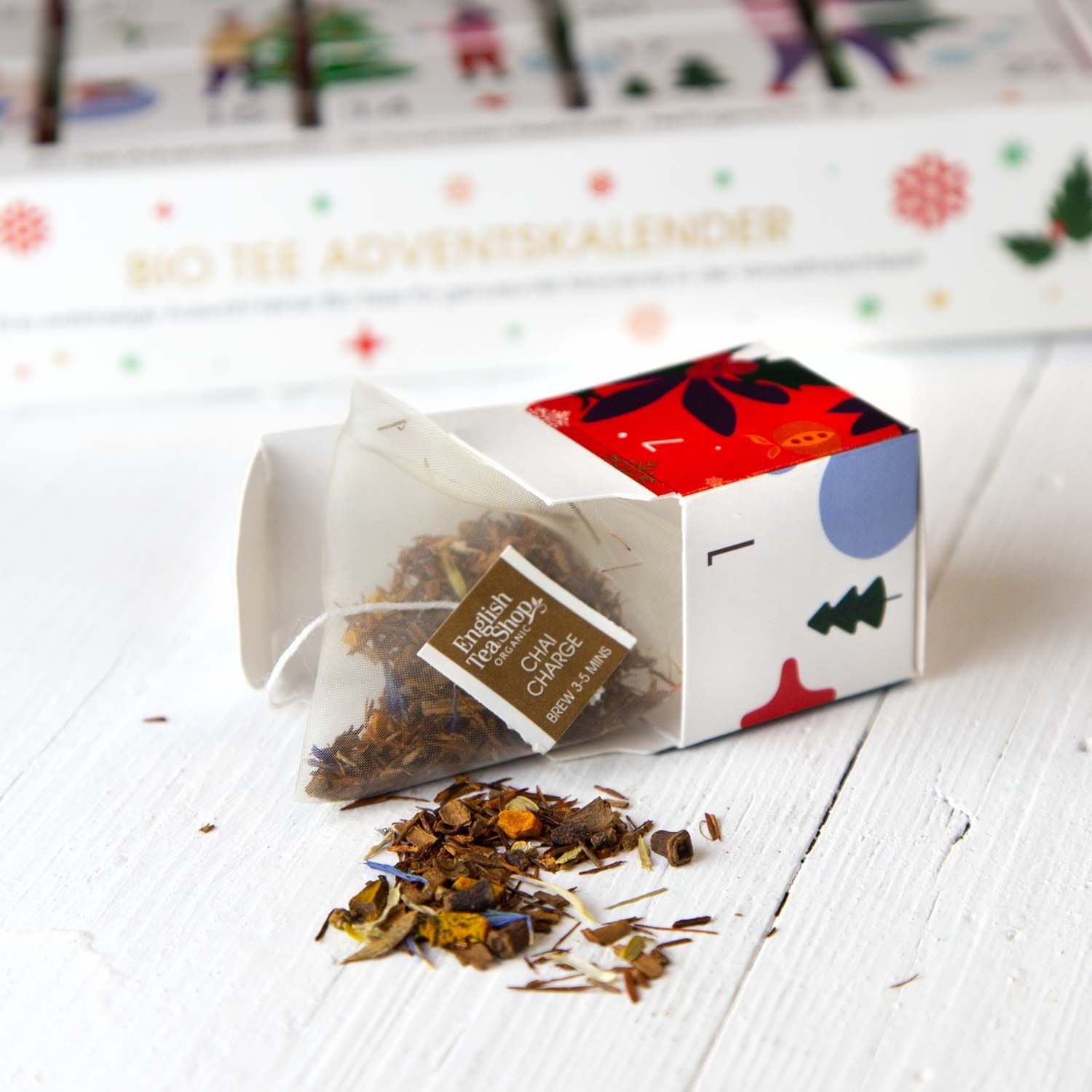 Geöffneter Teebeutel mit loser Teemischung und der Marke English Tea Shop. Der Teebeutel liegt neben der geöffneten Adventskalenderbox.