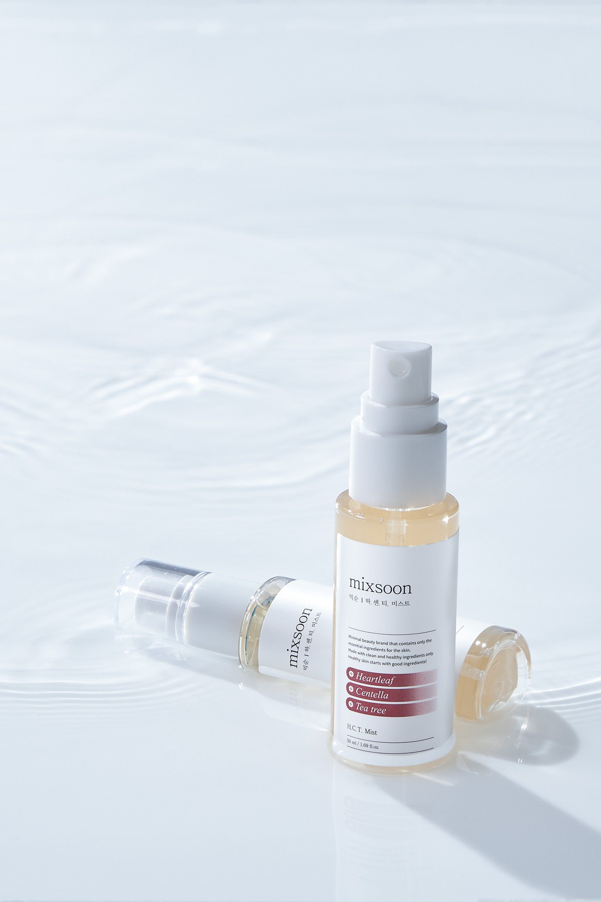 Zwei "mixsoon H.C.T. Mist" Sprühflaschen auf Wasser. Eine liegt, eine steht. Transparente Flaschen mit weißem Sprühkopf.