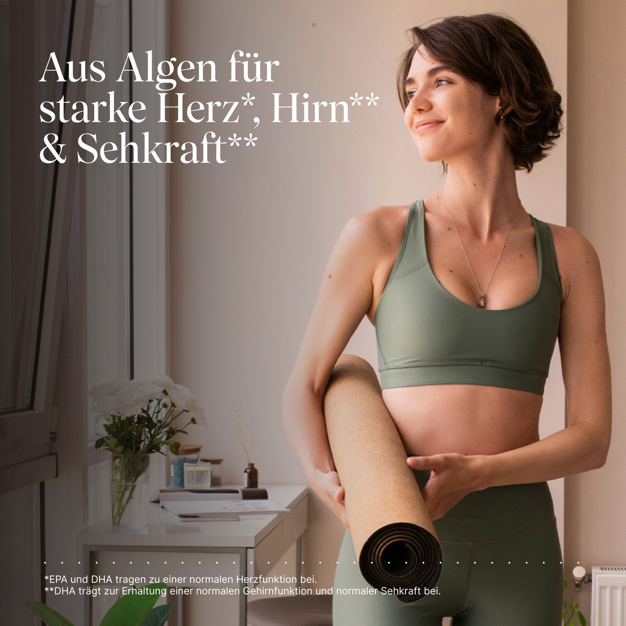 Frau mit Sportkleidung hält Yogamatte. Text: "Aus Algen für starke Herz, Hirn & Sehkraft". Hintergrund: hell, Fenster, Tisch.